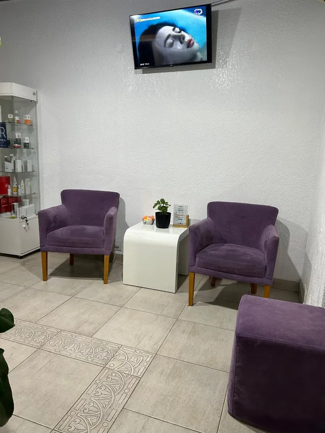 Sala de espera con sillones violetas y vitrina de productos